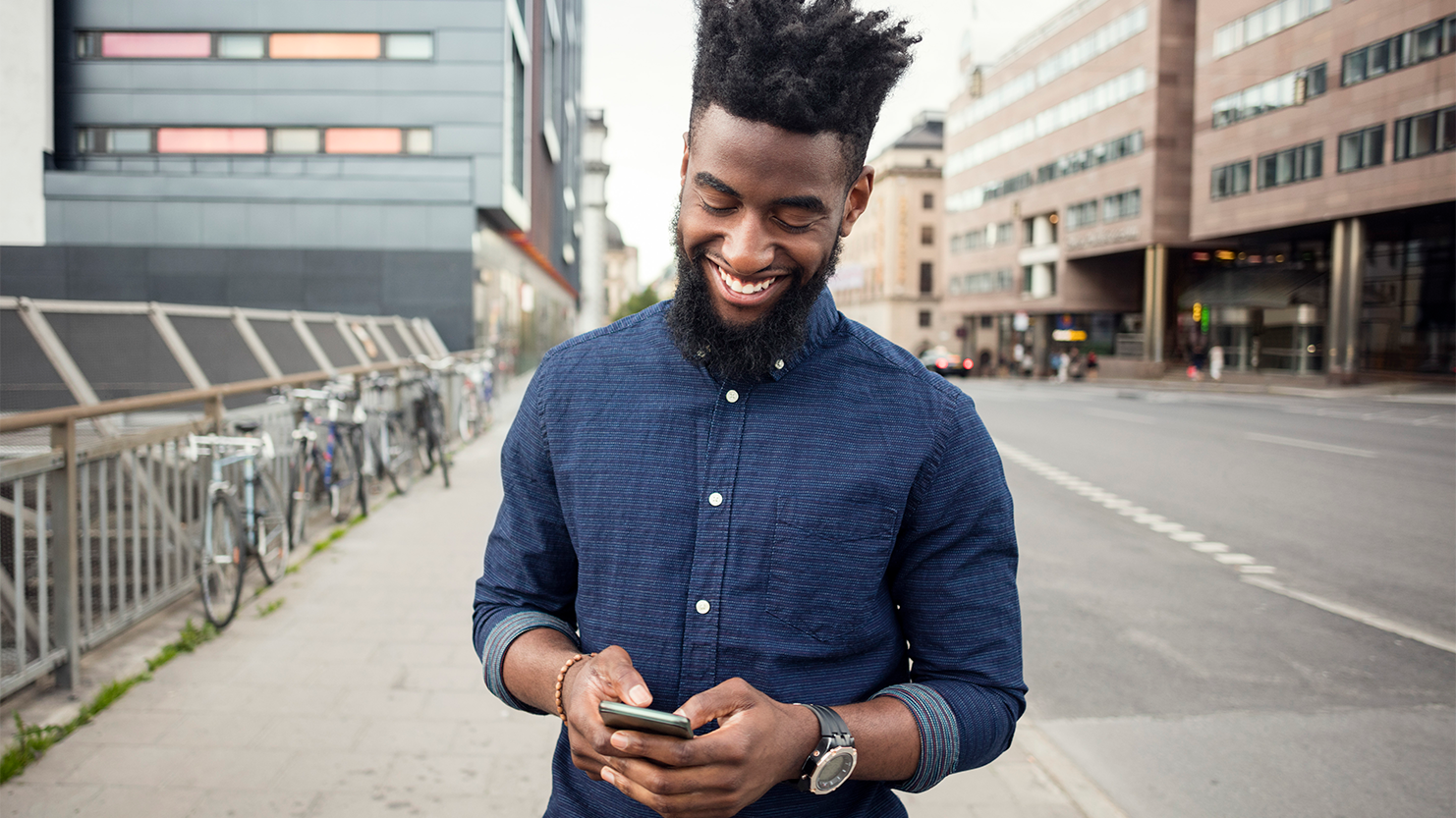 Man smiling and looking at phone